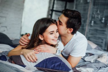 Genç çekici çift evde yatakta romantik zaman