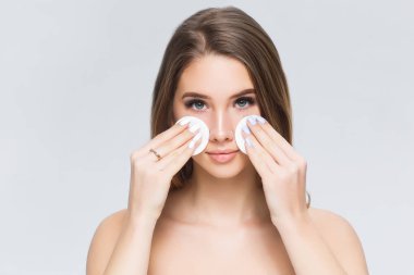 Genç kadın beyaz arka planda izole makyaj alıyor