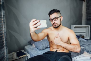 adam evde sabah smartphone üzerinde selfie yapma