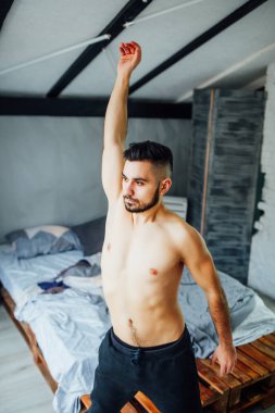 Yakışıklı sakallı adam evde pencere yakın karın egzersizleri yapıyor 