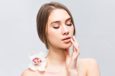 Beyaz arka plan üzerinde izole orkide olan güzel kadın portresi