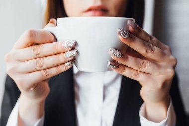 Beyaz fincanda sütlü kahve ya da elinde çay olan kadın.!