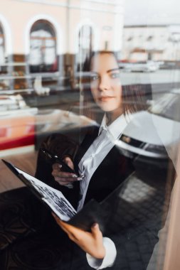 Kafede akıllı telefon kullanan muhteşem genç iş kadını, seçici odak