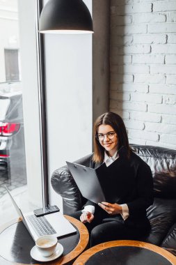 Pretty genç iş kadını işyerinde oturan dizüstü bilgisayar kullanarak