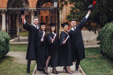 Çok ırklı mezunların diploması ve gülümsemesi portresi