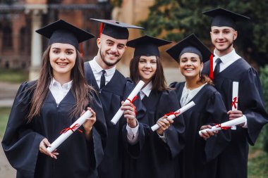 Beş üniversite mezunu sırada bekliyor ve gülümsüyor