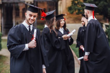 harç panoları ve diplomalı bekar lık önlüklerinde mutlu uluslararası öğrenci grubu