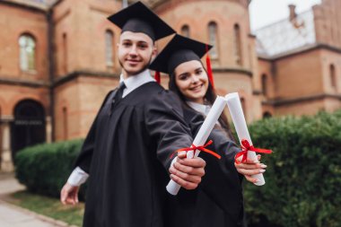 Mantolu diploma tutan iki gencin fotoğrafı