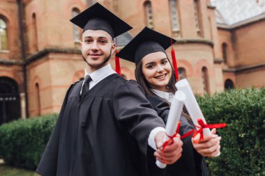 Mantolu diploma tutan iki gencin fotoğrafı