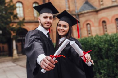 Mantolu diploma tutan iki gencin fotoğrafı