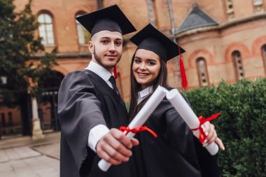 Mantolu diploma tutan iki gencin fotoğrafı