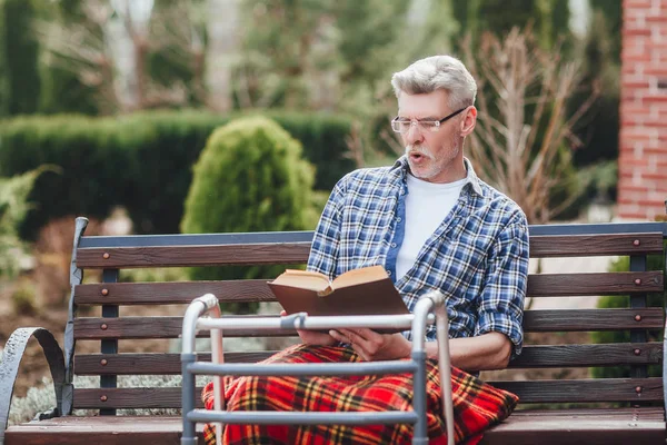 Anciano Leyendo Libro Mientras Encuentra Jardín Cerca Clínica — Foto de Stock