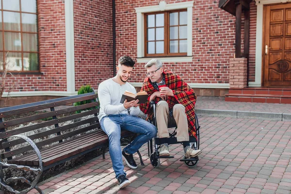 Hombre Con Padre Cerca Del Hogar Ancianos Libro Lectura — Foto de Stock