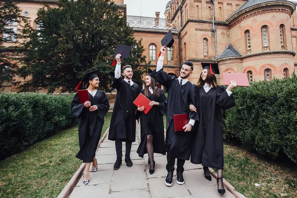 Молодые Выпускники Делают Командный Жест Дипломами — стоковое фото