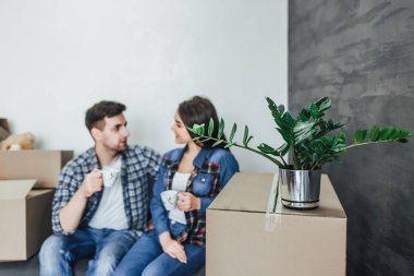 Kahve ile yeni bir evin planı tartışırken rahat giysiler içinde güzel çift 