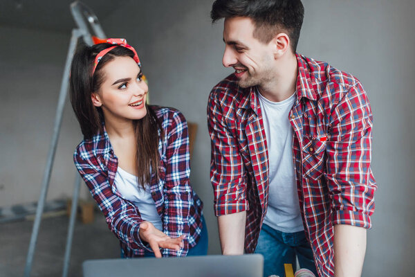 Young man and woman unpleasantly surprised while doing online shopping