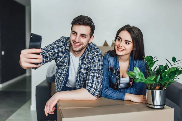 Genç çift yeni eve taşınıyor ve selfie çekiyor.