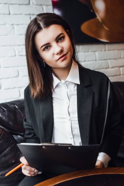 Elinde siyah klasör olan genç iş kadını, seçici odaklı.