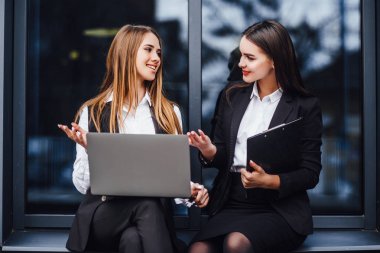 İş etkinliğinden önce olası çalışma sorularını tartışan formalgiyimli iki kültürlerarası çalışma arkadaşı!
