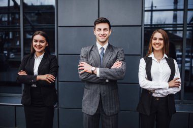 Ofis binasının yanında duran üç iş adamı