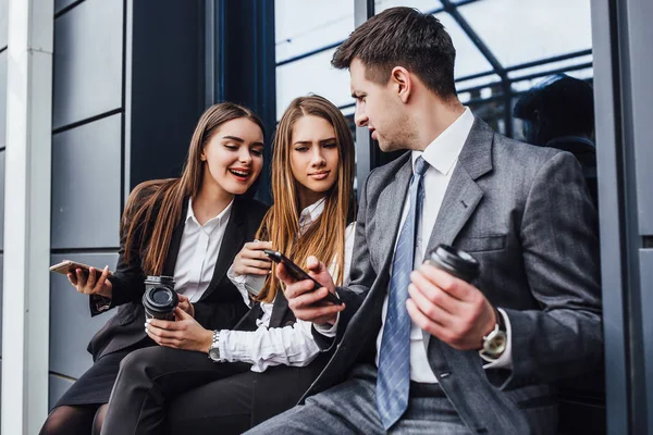 Tres Jóvenes Empresarios Que Toman Café Usan Teléfonos Inteligentes — Foto de Stock