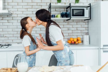 Mutfakta yemek pişirirken öpüşen iki güzel kız kardeş