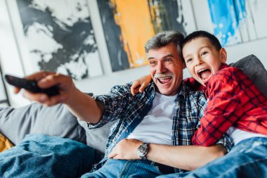 mutlu çocuk ve dedesi evde film izlerken