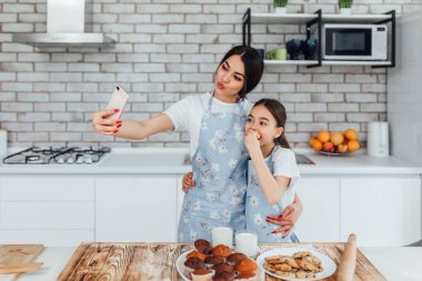 kız kardeşler mutfakta birlikte yemek pişirip selfie çekerken 
