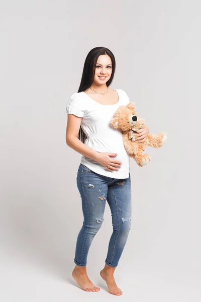白いシャツとジーンズの美しい妊娠中の女性は 白い背景に隔離 — ストック写真