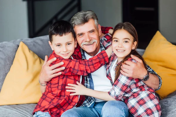 Feliz Abuelo Alegre Sonriendo Sentado Sofá Con Nietos —  Fotos de Stock