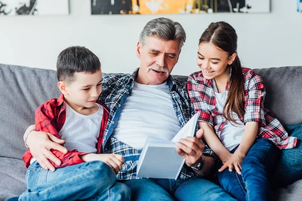 Großvater Liest Buch Für Kinder Während Hause Ruht — Stockfoto