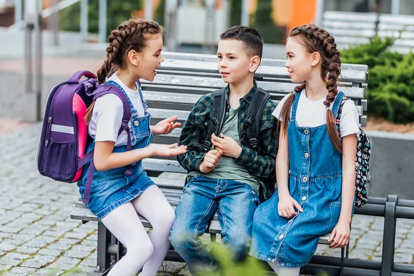 Grupo Estudiantes Escuela Primaria Feliz Con Mochilas Sentados Cerca Escuela — Foto de Stock