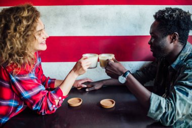 Kadın bir erkekle barda dinleniyor, konuşuyor, gülüyor, fast food yiyor.