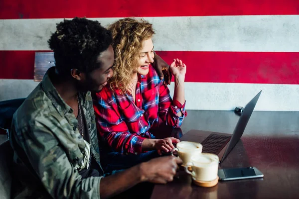 woman resting in bar with man, talking, laughing, eating fast food