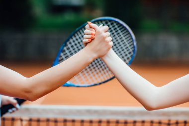 raket karşı tenis kortu üzerinde el sıkışırken kadınlar