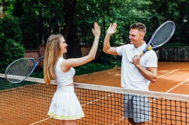 Oyun oynadıktan sonra tenis kortunda çift el sıkışma