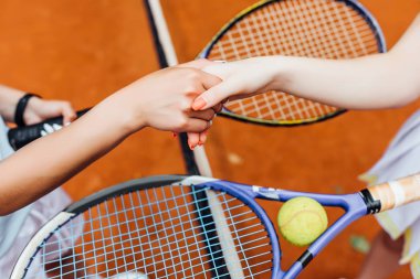 tenis kortu üzerinde el sıkışan kadınlar, kırpılmış görünümü 