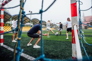 Sahada birlikte futbol oynayan bir grup arkadaş, net ten görünüm