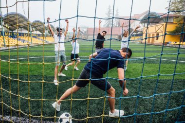 Sahada birlikte futbol oynayan bir grup arkadaş, net ten görünüm