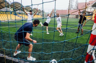 Sahada birlikte futbol oynayan bir grup arkadaş, net ten görünüm