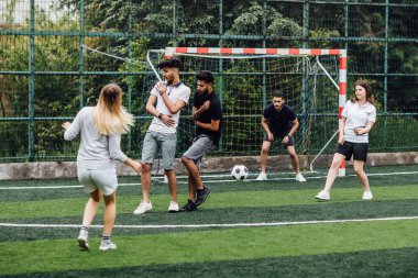 Bir grup arkadaş birlikte stadyumda futbol eğitimi