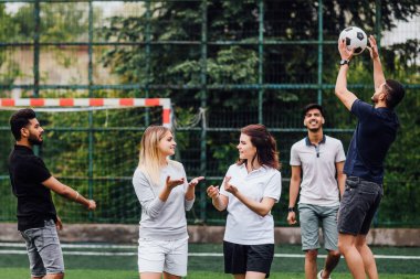 erkekler arka planda futbol topu ile oynarken kadın konuşma