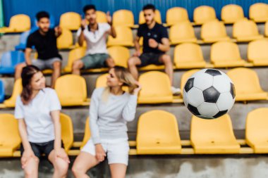 arkadaşlar sandalyede oturan, havada futbol topu, seçici odak 
