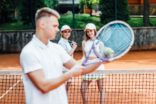 Adam güçlü atış yapmak için iki eliyle tenis raket sallanan