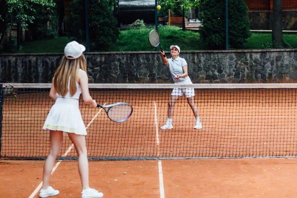Дві Красиві Жінки Шапочці Тенісної Форми Подають Тенісний Під Час — стокове фото