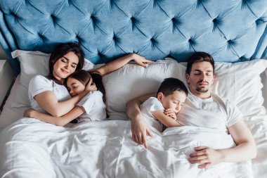 evde yatakta birlikte vakit geçiren aile  