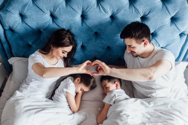 evde yatakta birlikte vakit geçiren aile  