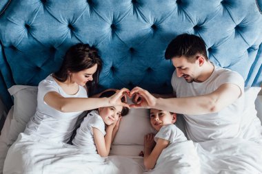 evde yatakta birlikte vakit geçiren aile  