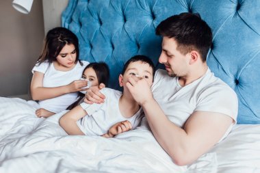 evde yatakta birlikte vakit geçiren aile  