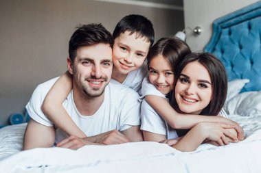 evde yatakta birlikte vakit geçiren aile  